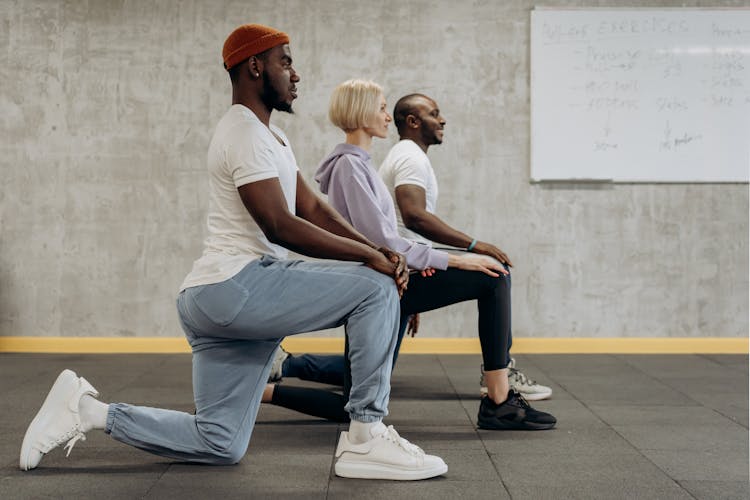 Three People In A Kneeling Position