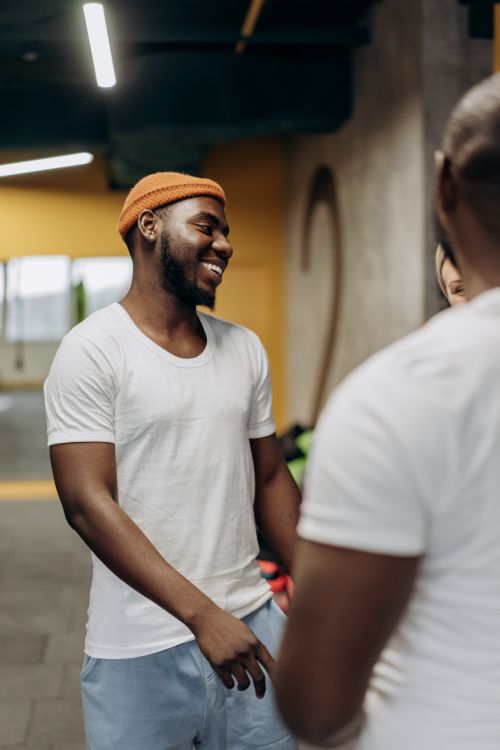 Free A cheerful group of diverse adults socializing and laughing together in a modern gym setting. Stock Photo