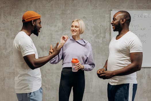 Three adults having a lively discussion in an indoor gym setting.