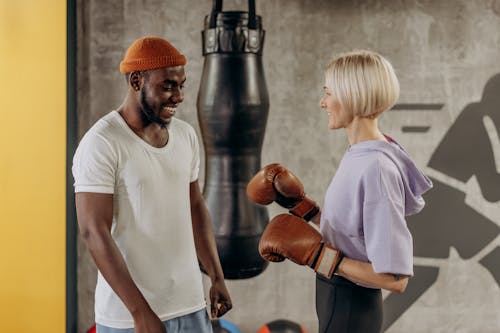 Woman Wearing A Boxing Gloves With Trainer Beside Her