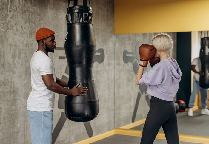 Two members training together on a punching bag