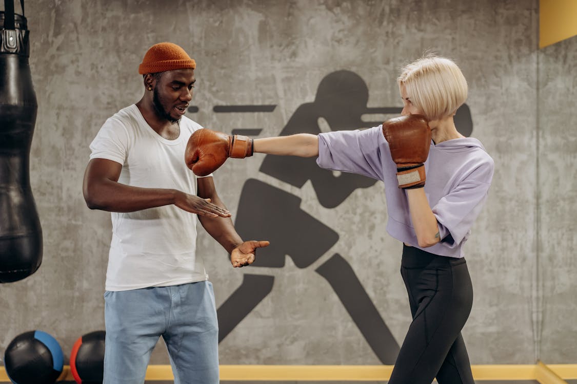 Man Training Woman In Boxing