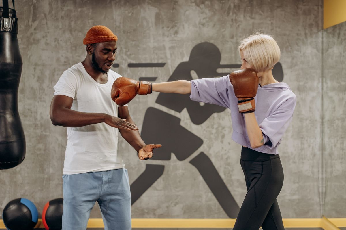 A boxer working pads with a coach indoors.