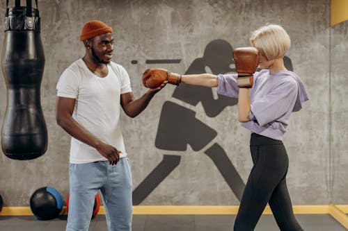 Man Training A Woman How To Punch In Boxing