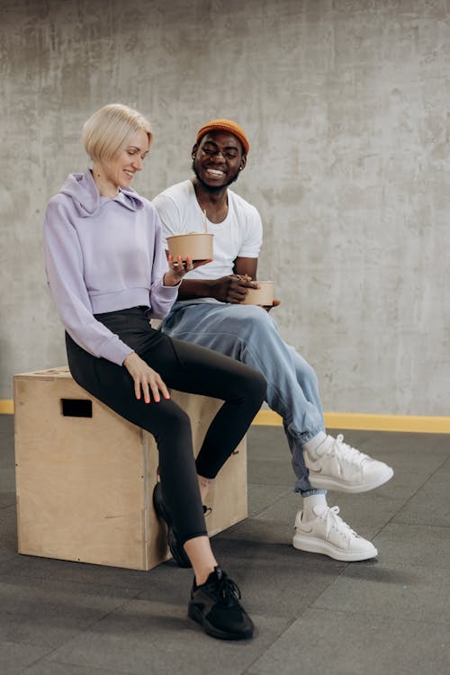 Free Man And Woman Sitting On A Box With Rice Bowls  Stock Photo