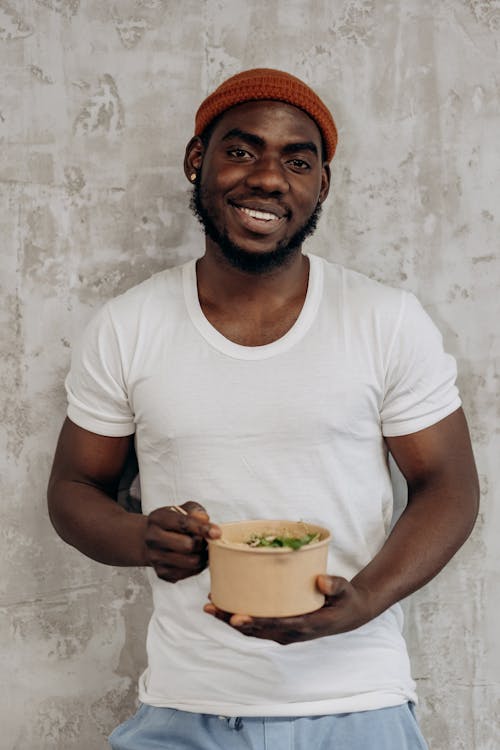 Man in White Crew Neck T-shirt Holding A Rice Bowl