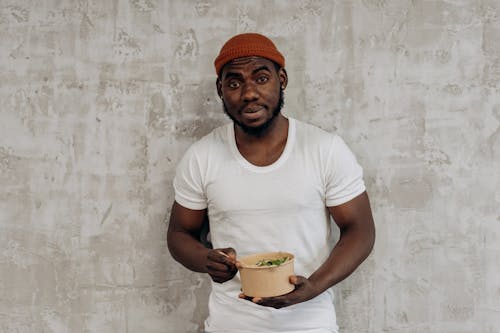 Man in White Crew Neck T-shirt Eating In A Bowl