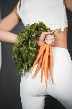 A woman in a studio holding fresh carrots, showcasing healthy living and fitness.