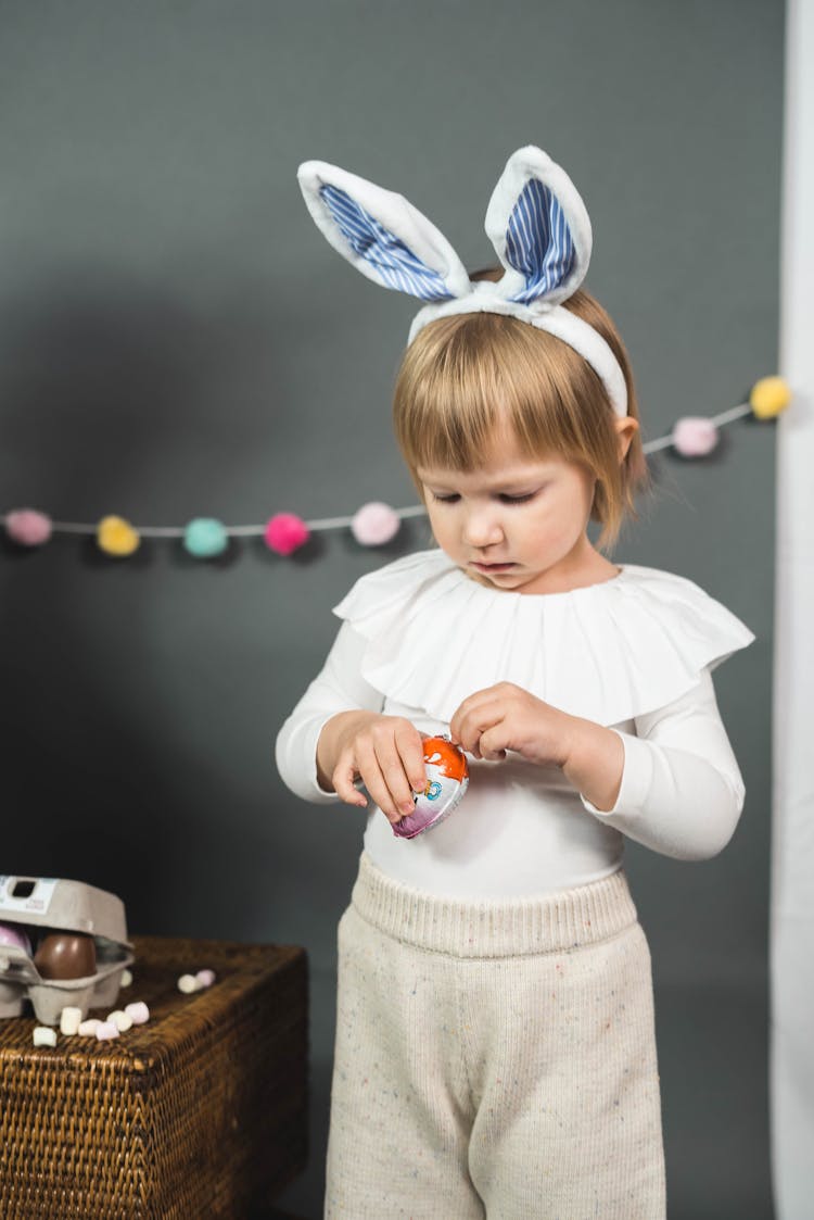 A Kid Unwrapping A Chocolate