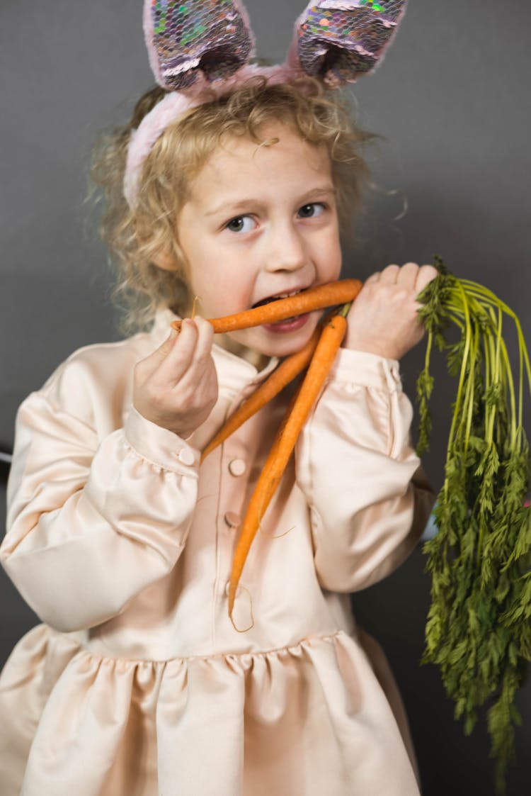 A Girl Biting A Carrot 