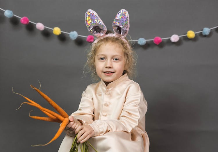 Child Holding A Bunch Of Carrots