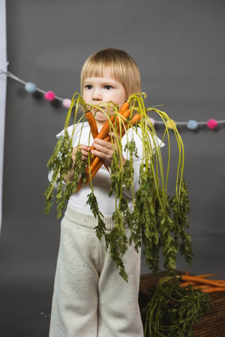 Cute Child Holding Carrots