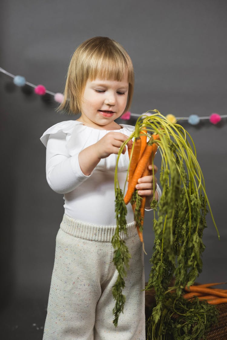 Happy Child Holding Carrots