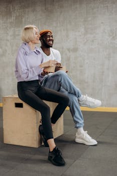 Two young adults enjoying healthy meals in a casual indoor setting.