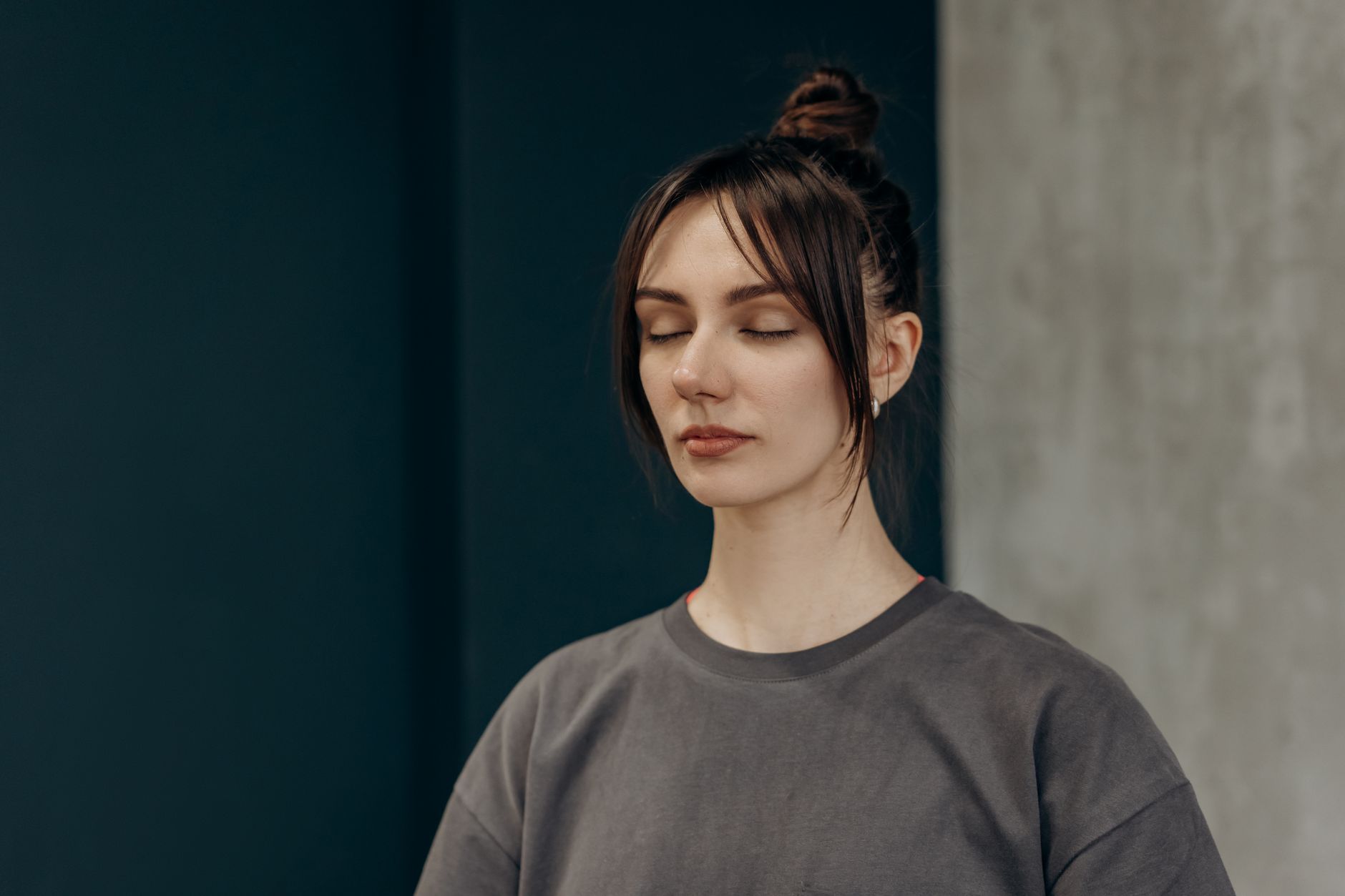 冥想教學中的「無努力」原則:定義、應用與益處 Serene young woman with closed eyes meditating indoors. Embracing tranquility and mindfulness.