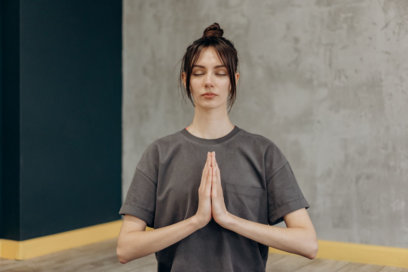 Woman sitting cross-legged with eyes closed practicing meditation and breathing as part of an eye yoga and relaxation routine