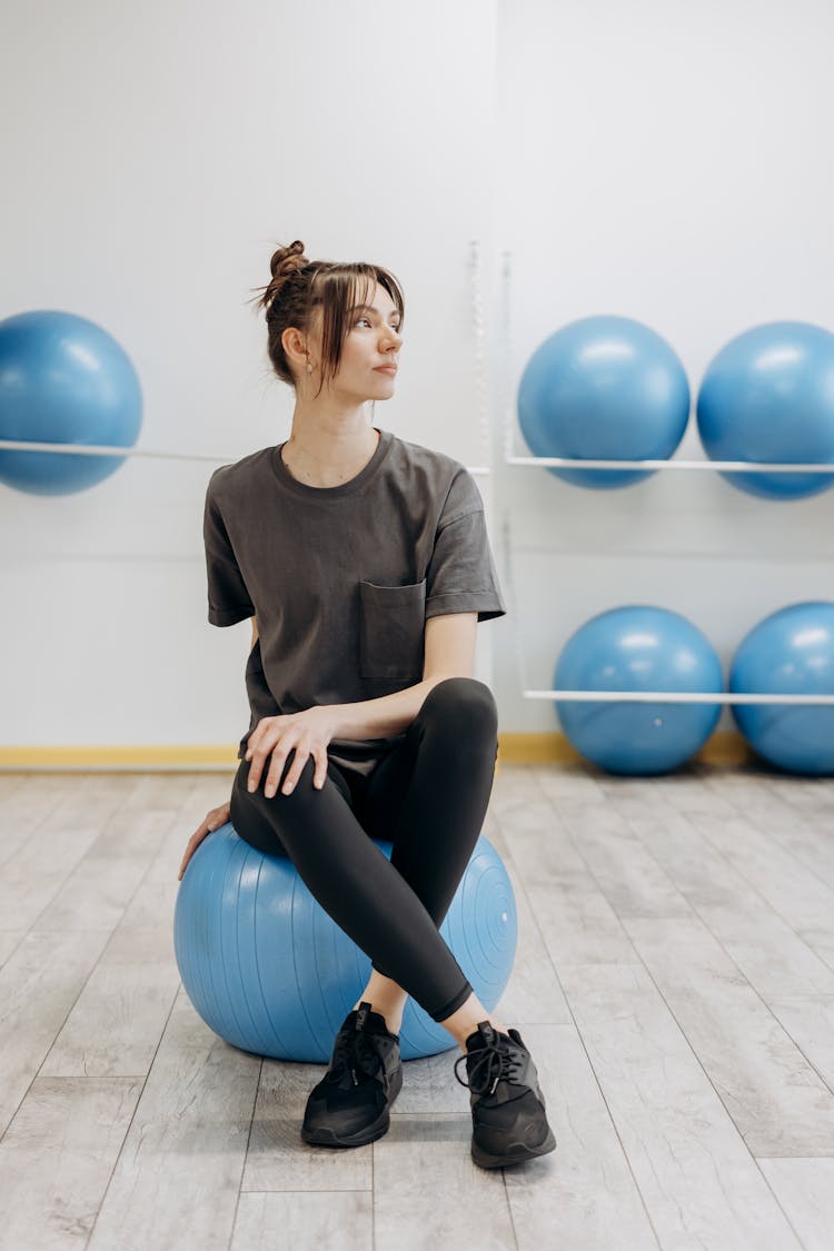 Woman Sitting On A Blue Yoga Ball