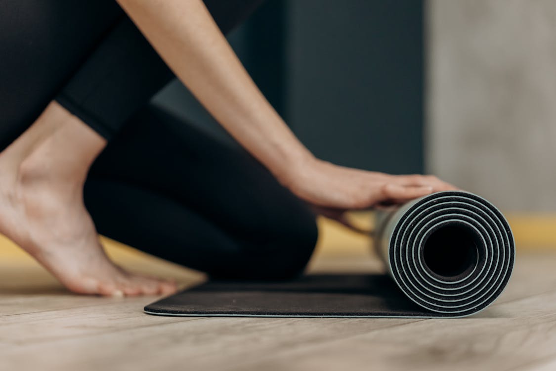 Woman Rolling A Yoga Mat