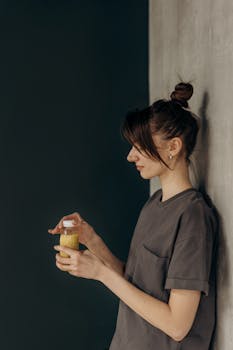A young woman enjoying a refreshing juice indoors, embracing a healthy lifestyle.