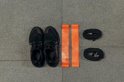 Flat lay of fitness essentials: sneakers, resistance bands, and straps for training.