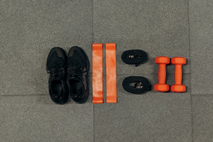 Black Sneakers And Gym Tools On Gray Floor