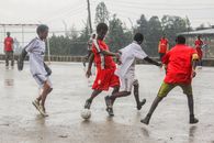 Men Playing Soccer Under the Rain