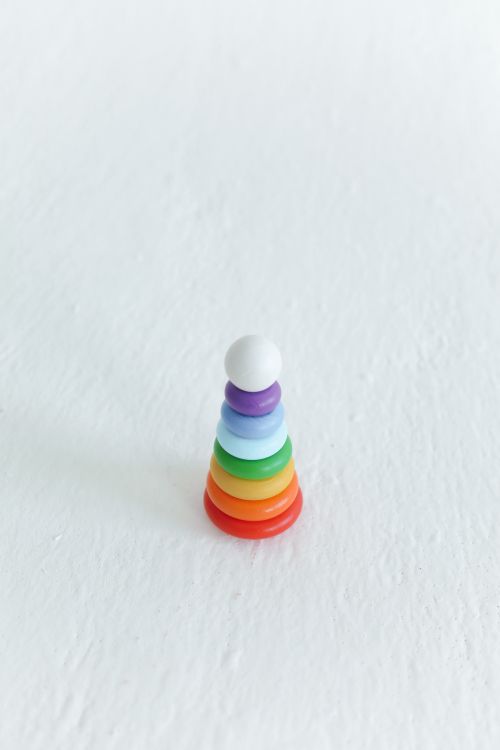 Free Brightly colored stacking toy on a white background, symbolizing fun and learning. Stock Photo