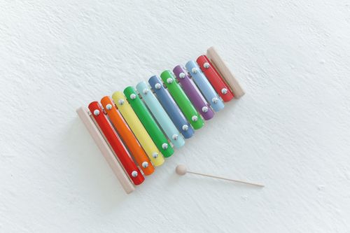 Free Brightly colored xylophone with wooden mallet on a white surface, showcasing vibrant musical tones. Stock Photo