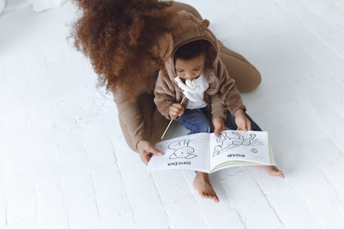Free A Woman and a Child Looking at a Picture Book Stock Photo