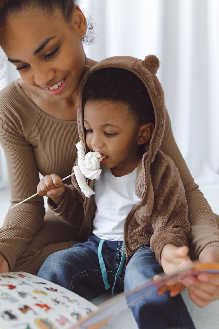 A Boy Eating A Candy On Stick