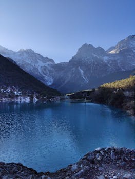 Tranquil lake with snowy mountains in Blue Moon Valley, Yunnan, China.