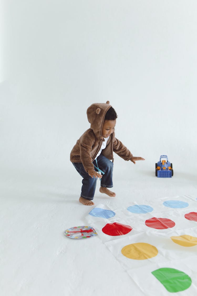 Cute Child In Front Of Twister Mat 