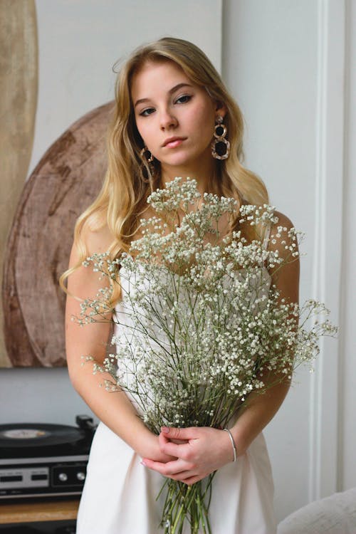 Free Woman in White Floral Dress Holding Green Plant Stock Photo