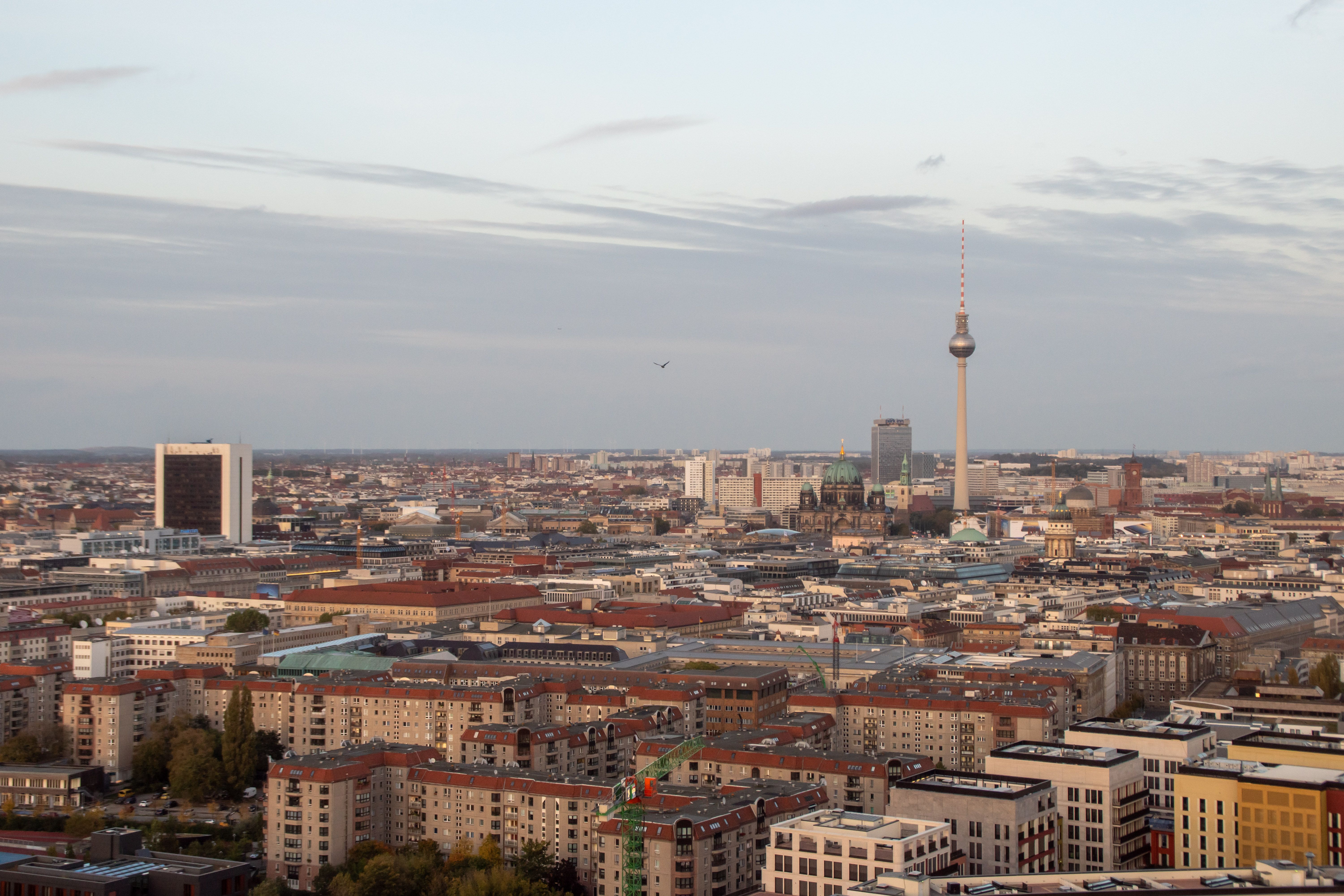 Aerial view of Berlin cityscape featuring the iconic TV Tower under a clear sky.