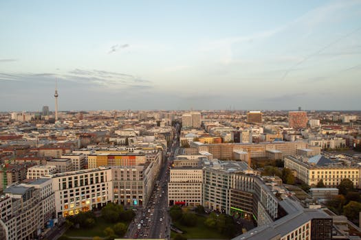 Panoramic aerial view of Berlin's skyline with iconic TV Tower visible against the evening sky.