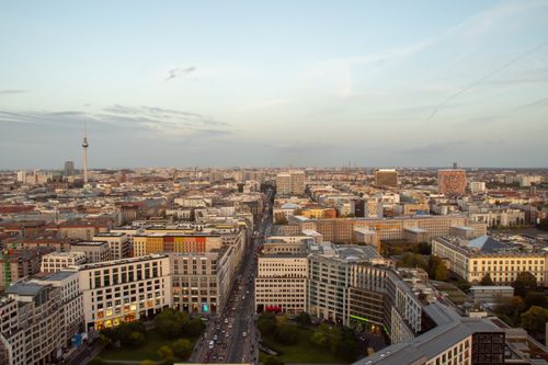 Free Panoramic aerial view of Berlin's skyline with iconic TV Tower visible against the evening sky. Stock Photo
