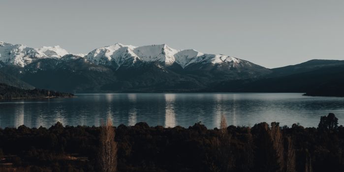 Breathtaking view of snow-capped mountains reflecting in a serene lake.