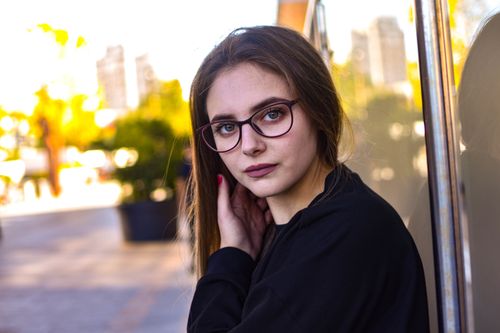 Free Portrait of a stylish woman wearing glasses, outdoors in an urban setting during the day. Stock Photo