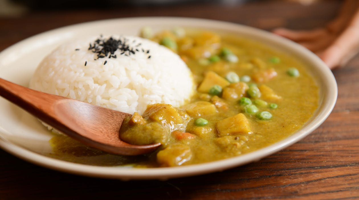 Arroz Cocido Y Alimentos Al Curry Servidos En Un Plato Blanco