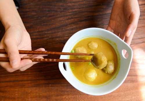 Free Person Holding Chopsticks and White Ceramic Bowl Stock Photo