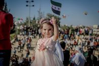 Girl with Syrian rebel flag in crowd of people