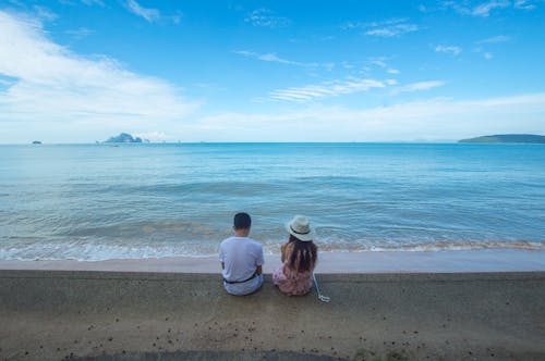 無料 海岸に座っている男性と女性 写真素材
