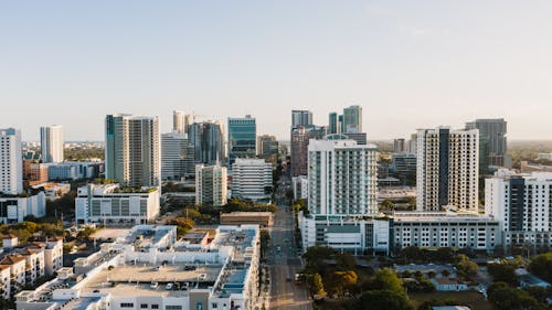 Scenic cityscape of Fort Lauderdale downtown with modern multistory buildings and glass skyscrapers against cloudless sunset sky