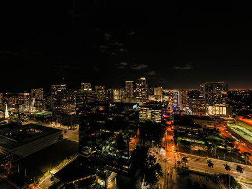 Free Drone view of asphalt roads and skyscrapers with glowing light and neon illumination in Fort Lauderdale at night Stock Photo