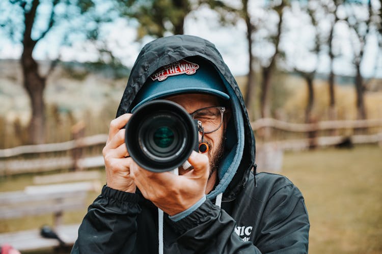 Man In Black Hoodie Taking Picture