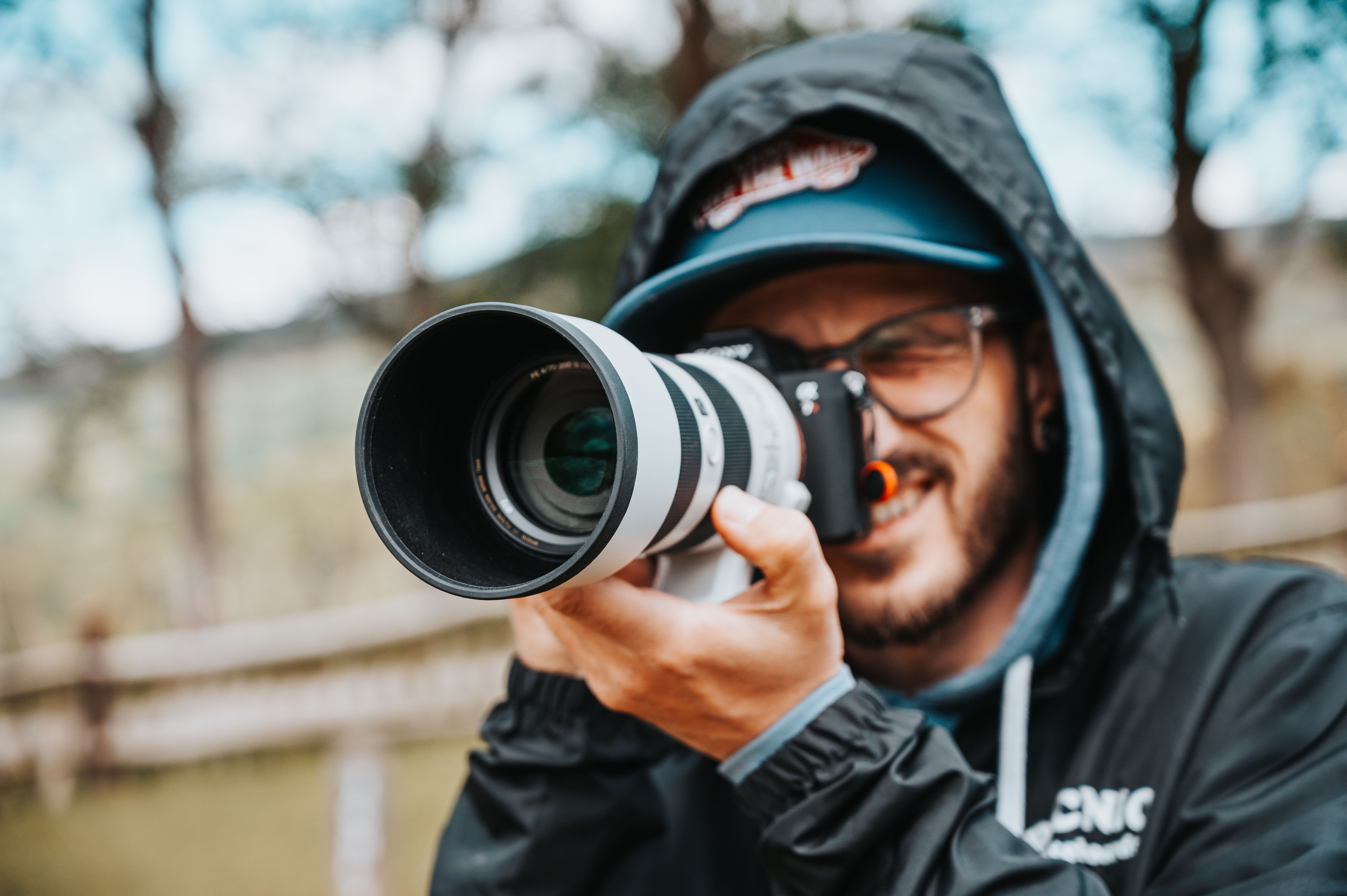 A focused photographer captures moments outdoors using a DSLR camera.