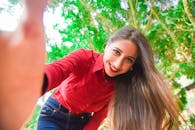 明媚的夏日里，一位微笑的女人在公园里自拍，散发着欢乐和放松