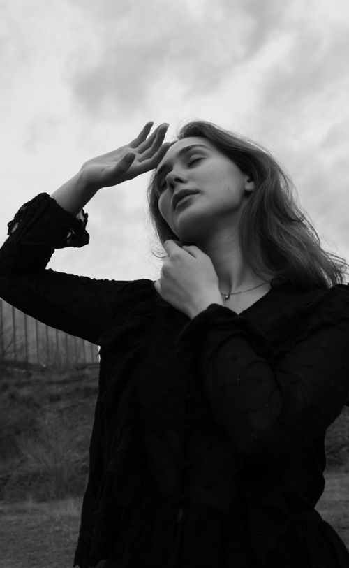 Free Elegant black and white portrait of a woman with thoughtful pose outdoors. Stock Photo