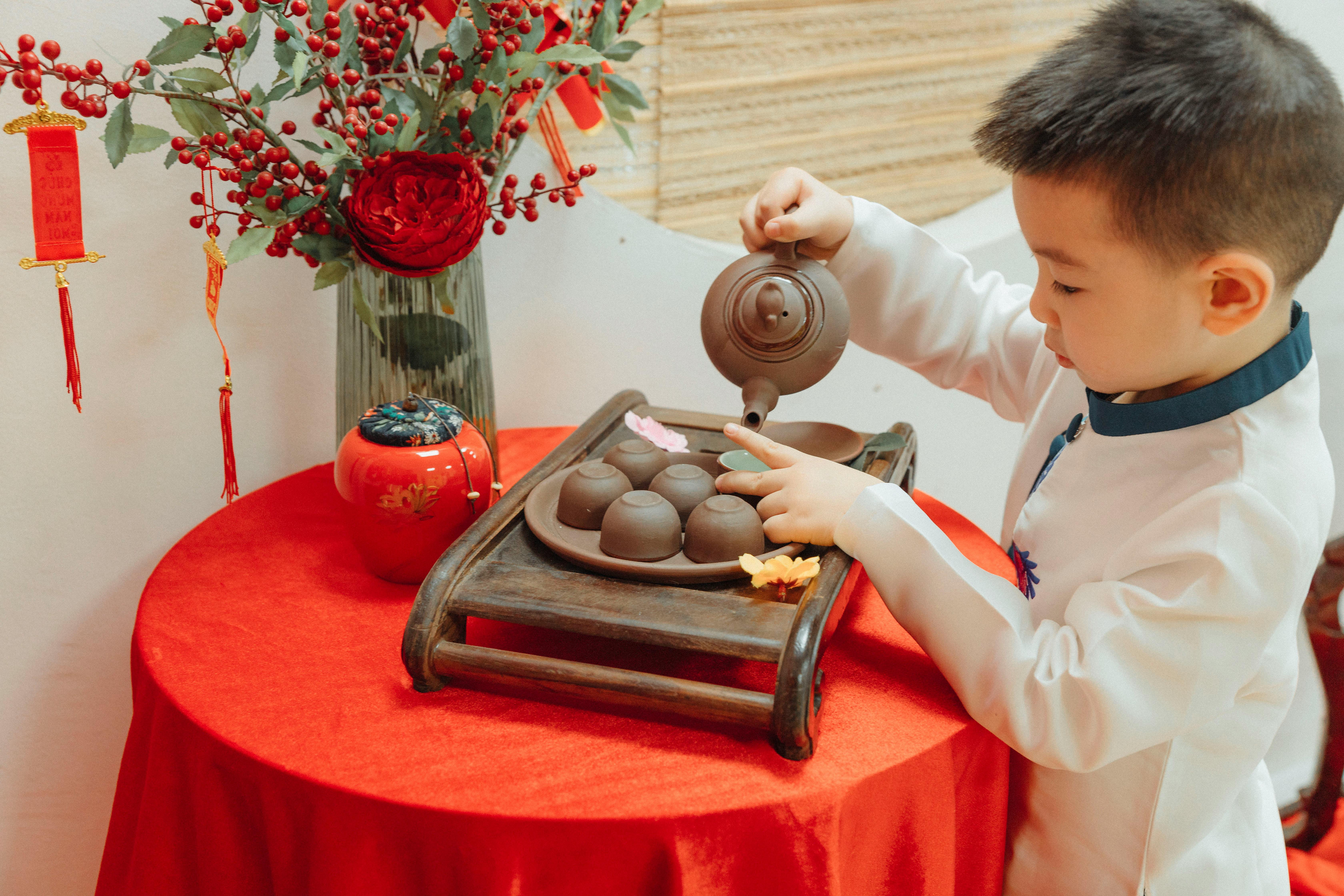 a boy pouring tea on a teacup