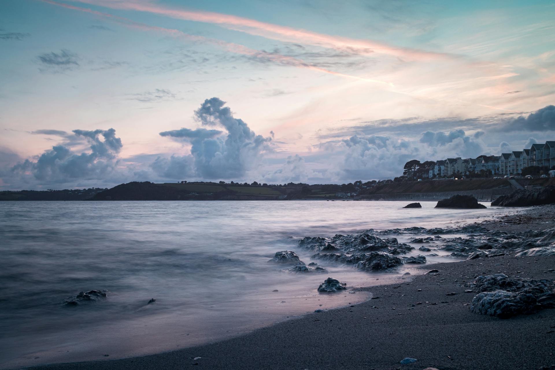 Breathtaking sunset view of Falmouth's rocky beach and tranquil sea, offering a peaceful escape.
